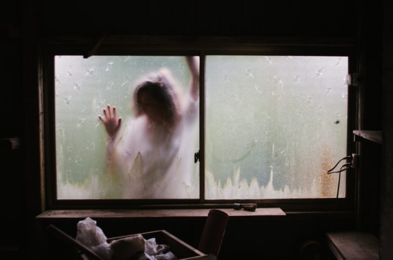 Frau steht vor dem Fenster und kommt nicht rein (Photo by Priscilla Du Preez on Unsplash)